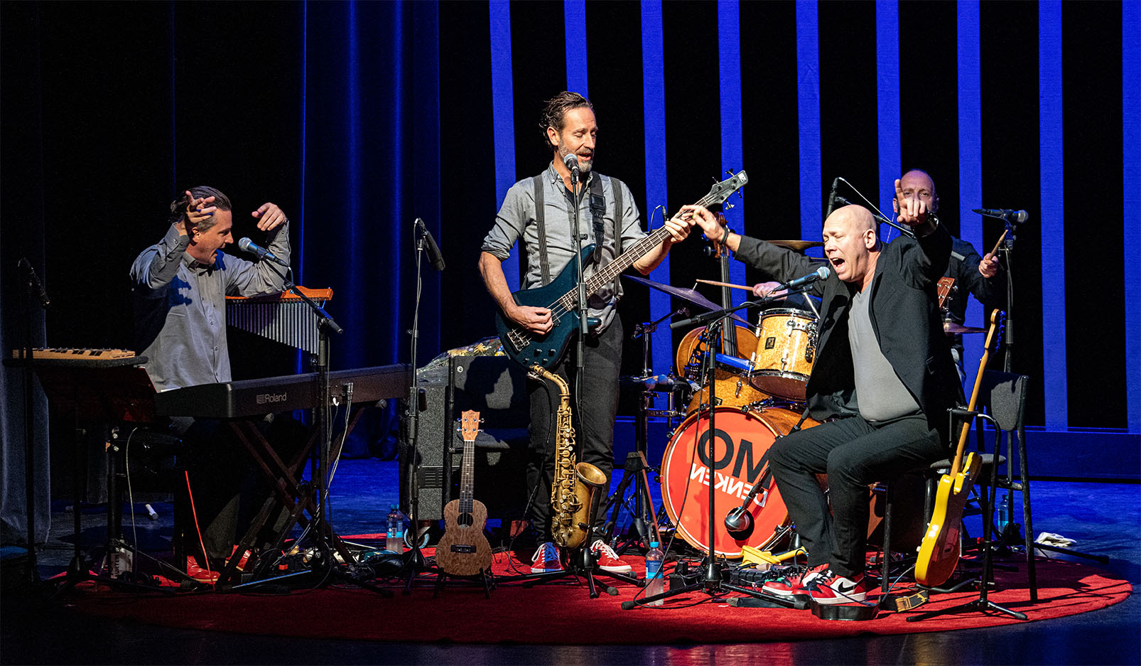 Band treedt live op op een podium met zang, gitaar en drums