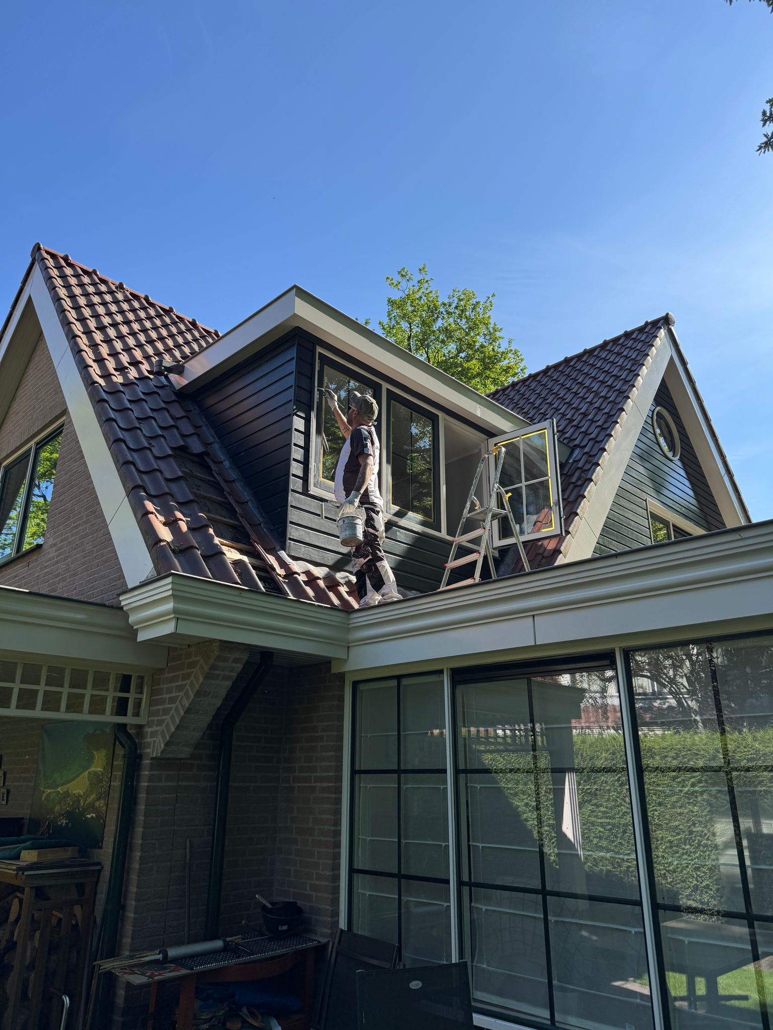 Schildersbedrijf Overdevest schildert een dakkapel op een woning